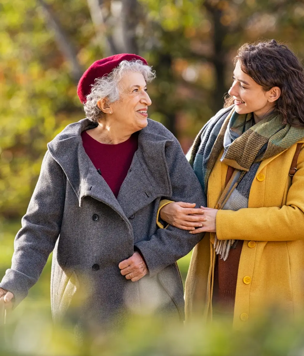 Two ladies in the park linking arms